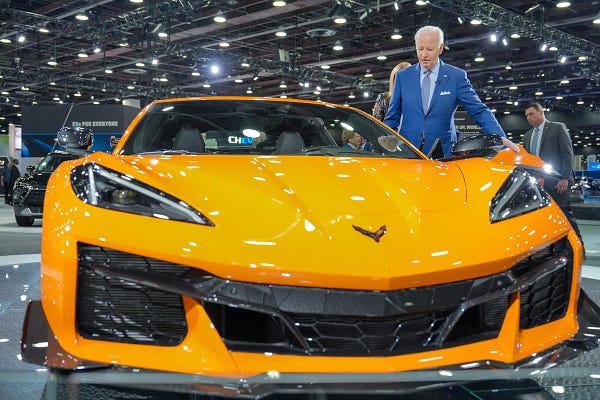 President Biden stands next to electric Corvette at the Detroit Auto Show.