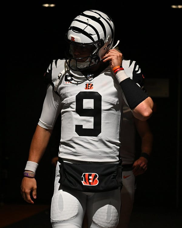 Picture of Joe Burrow wearing the Bengals' color rush uniform with a white, striped helmet
