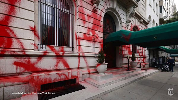 Red streaks of spray paint cover the facade of the Russian consulate in Manhattan. Photo by Jeenah Moon for The New York Times.