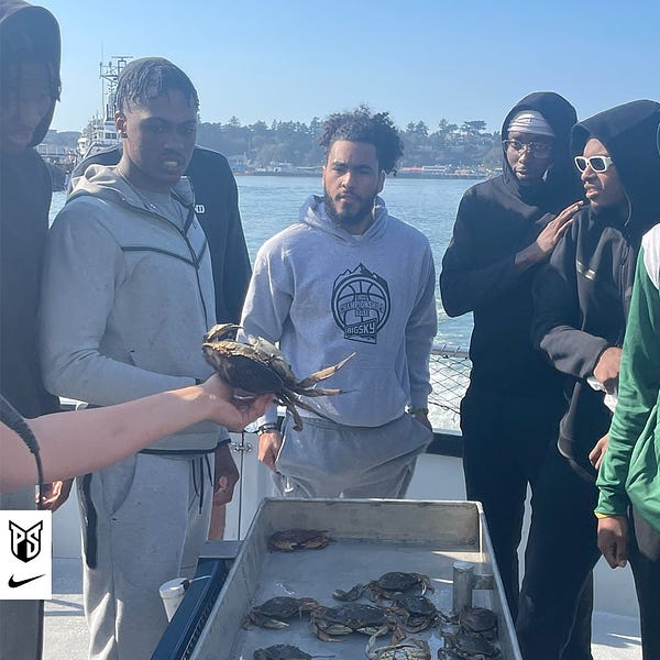 Bobby Harvey, Mikal Starks, Keshaun Saunders, and Cole Farrell look at a live crab.