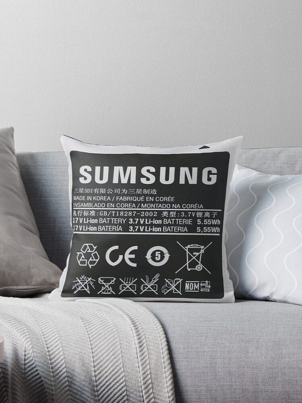 A square throw pillow that is styled to look like a "Sumsung" brand battery