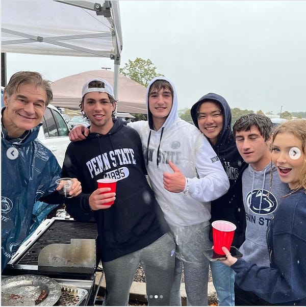 Oz sipping red wine at a tailgate with Penn State students.