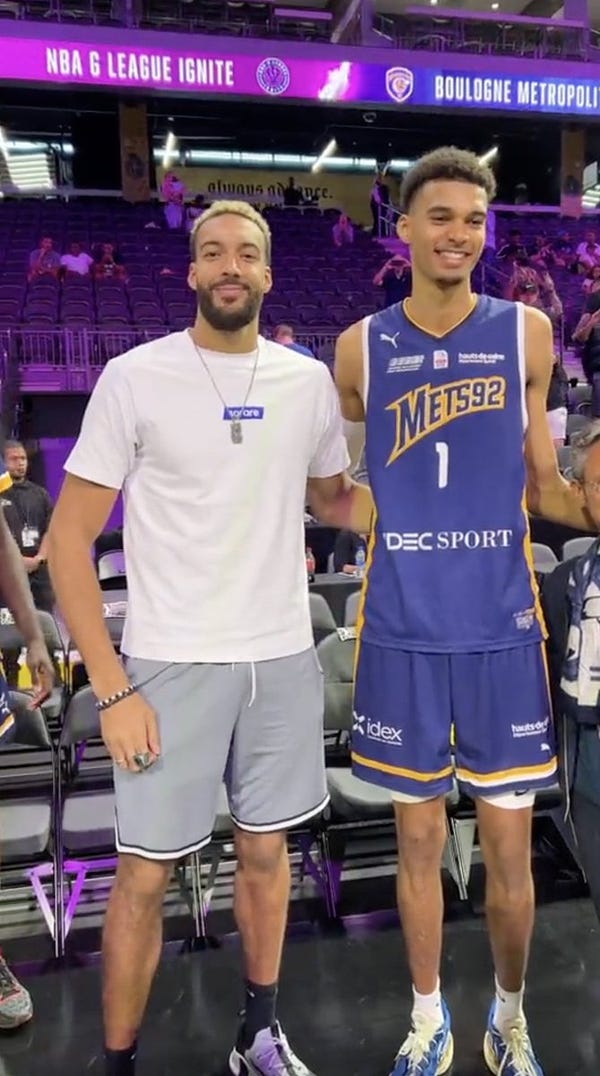 Picture of Rudy Gobert and Victor Wembanyama posing for the media. Wembanyama is taller than Gobert, who is seven-foot-one.