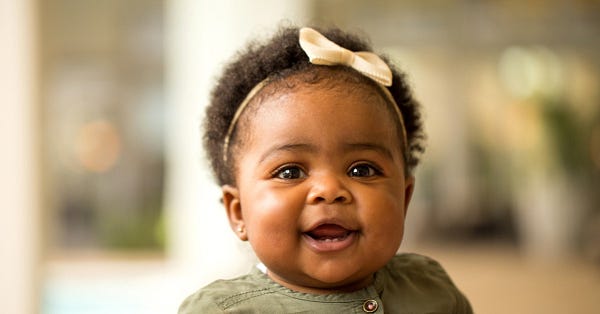 Baby wearing a bow smiling