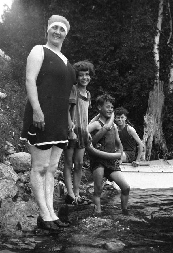 Rae Luckock wearing a bathing suit and standing with her daughter Fern and her sons Warren and Keith by a lake, circa 1930-1940 (F 4725)