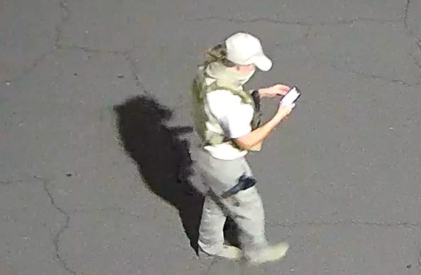 An armed individual dressed in tactical gear at a Mesa ballot drop box