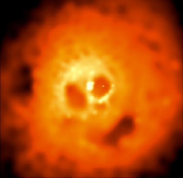 This haunting image from the orbiting Chandra Observatory reveals the Perseus Cluster of Galaxies in x-rays, photons with a thousand or more times the energy of visible light. From this angle, voids and bright knots in the x-ray hot gas cloud lend it a very suggestive appearance. Like eyes in a skull, two dark bubbles flank a bright central source of x-ray emission. A third elongated bubble (at about 5 o'clock) forms a toothless mouth. The bright x-ray source is likely a supermassive black hole at the cluster center with the bubbles blown by explosions of energetic particles ejected from the black hole and expanding into the immense gas cloud. Fittingly, the dark spot forming the skull's "nose" is an x-ray shadow ... the shadow of a large galaxy inexorably falling into the cluster center.