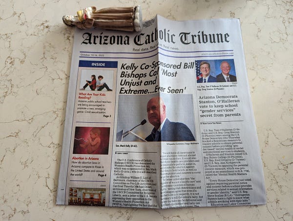 A newspaper titled the "Arizona Catholic Tribune", with the masthead "Real data. Real value. Real news." Dated October 10–16, 2022, website americancatholictribune.com. Headlines include: "Kelly Co-Sponsored Bill Biships Call 'Most Unjust and Extreme...Ever Seen'", "Arizona Democrats Stanton, O'Halleran vote to keep school 'gender services' secret from parents", and features include "What Are Your Kids Reading?" and "Abortion in Arizona". The paper bears a mail mark indicating it was sent from Kansas City, Missouri.