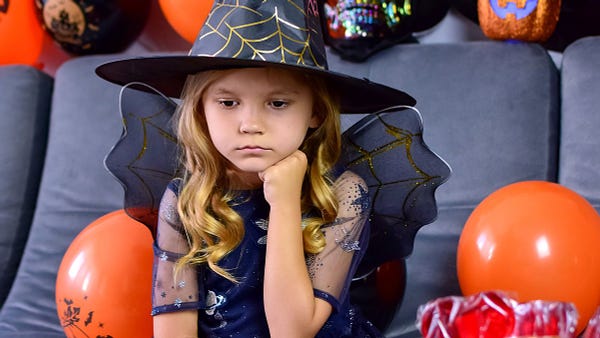 Little girl in costume frowning.