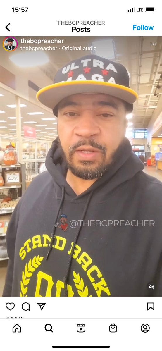 A Black main in his forties with a goatee. He is clearly speaking into the camera. He is wearing a ULTRA MAGA baseball cap where the cap hasn’t been rounded, and a PB sweatshirt that says Stand Back, Stand Boy around the original laurels.