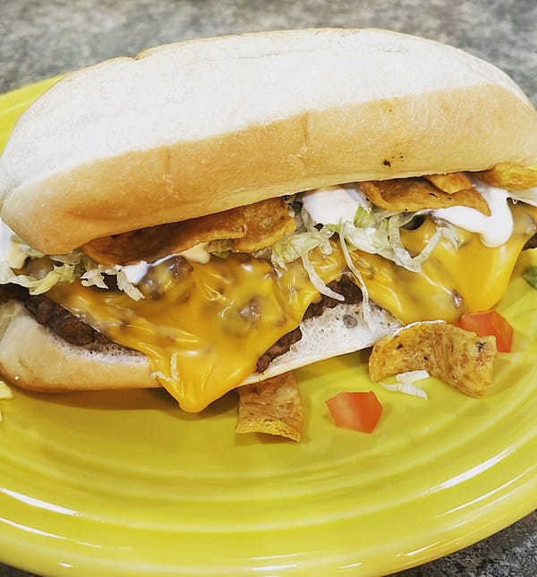 Sub with taco meat, melty cheese, shredded lettuce, tomato, sour cream, and Fritos.