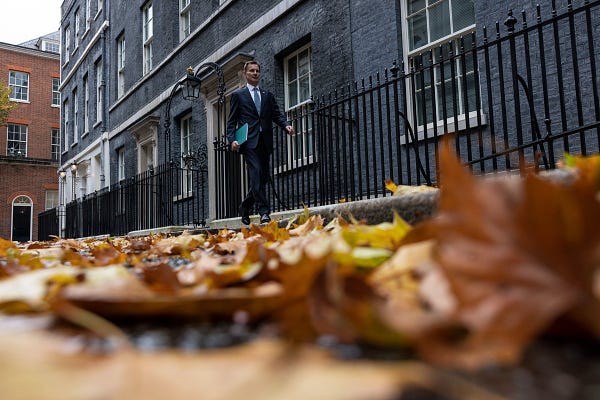 A floor level shot of Jeremy Hunt walking out of Number 11 on his way to deliver the Autumn Statement. Autumn Leaves can be seen on the floor.