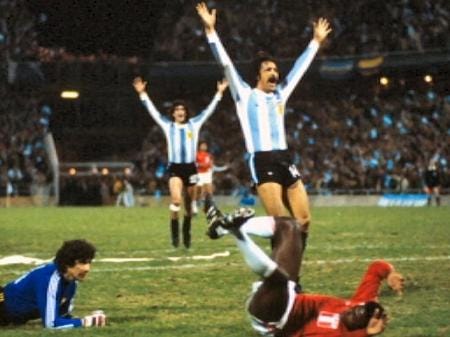 quatros jogadores em campo. dois estão com a camisa da Argentina com as mãos para cima. O jogador do Peru está deitado no gramado.