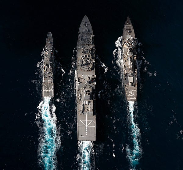 Three naval vessels conduct a dual RAS during Exercise Malabar 2022. Photo: Royal Australian Navy.