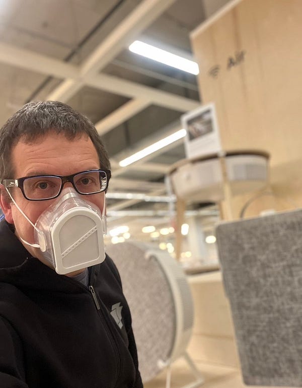 Man in white respirator in front of three air cleaners in IKEA.
