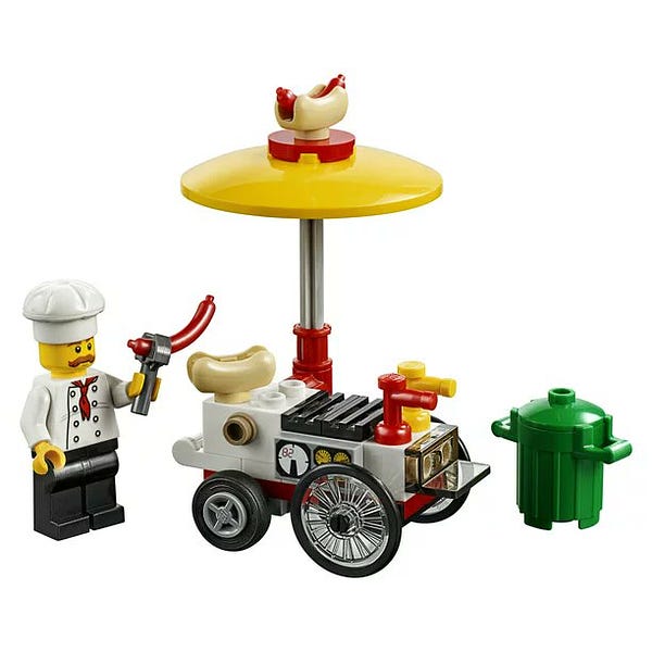 the hot dog vendor set by lego, completed, with a chef holding a hot dog