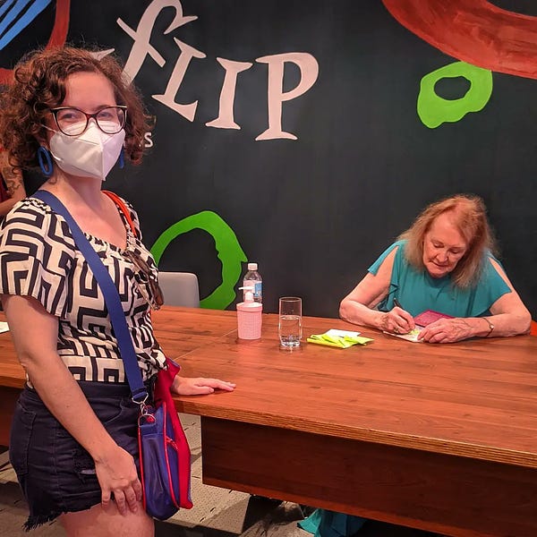 Foto minha em frente a Annie Ernaux autografando meu livro 