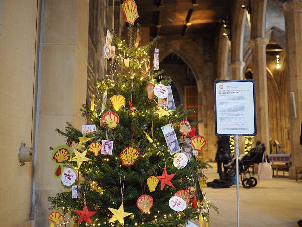 Christmas tree in cathedral, decorated with Shell logos and bank notes