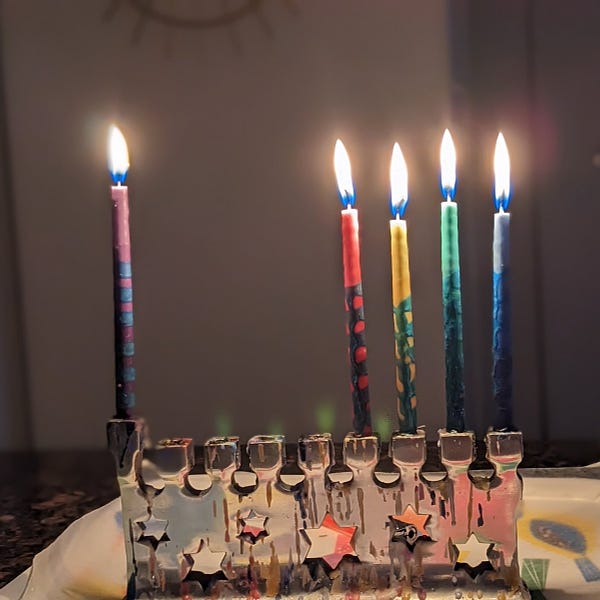 Menorah with rainbow candles lit for the fourth night of Chanukah