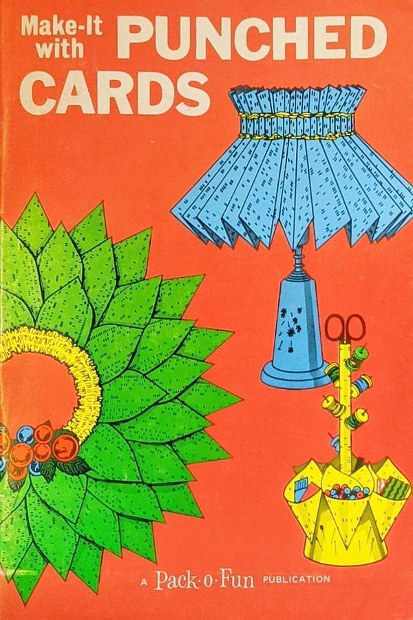 Cover of a vintage book titled "Make-it with Punched Cards". The cover shows a wreath and other things made from punch cards.