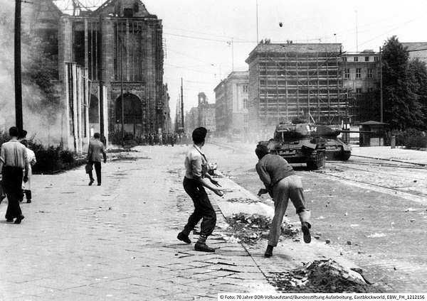 Volksaufstand in der DDR - 17. Juni 1953: Zwei Männer werfen mit Steinen nach einem Panzer. 