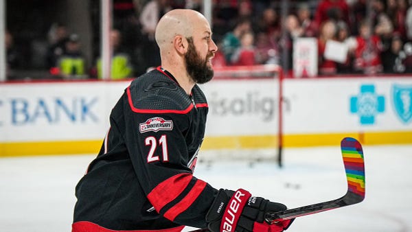 Photo of Derek Stepan during warmies with his stick taped with Pride Tape