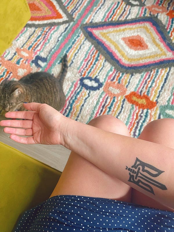 Nat’s trident tattoo and colorful rug. And cat. Because she too cares about these issues.