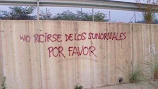 Pintada “No reirse de los sunormales por favor”