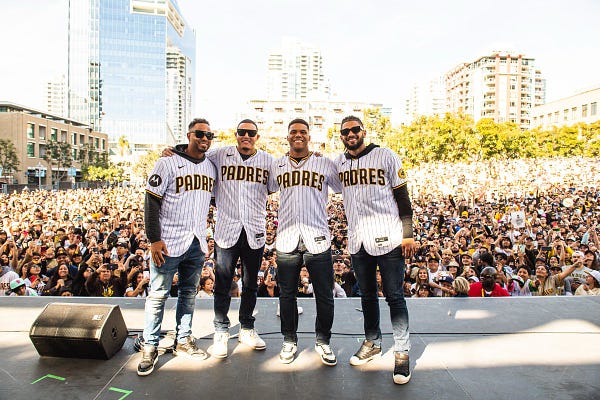 Photo: Xander Bogaerts, Manny Machado, Juan Soto and Fernando Tatis Jr. pose side-by-side and smile in front of a crowd of Padres fans at Petco Park.