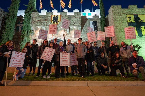 workers from medieval times in Buena Vista on strike tonight. They are posing for a group photo holding unfair labor practice signs in front of the business.