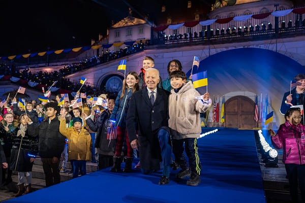 President Biden poses with children in Warsaw, Poland.