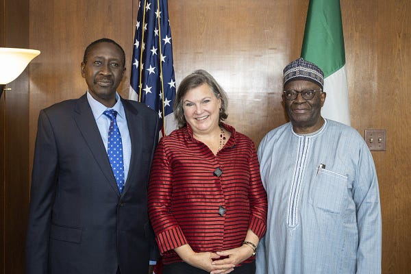 Under Secretary of State for Political Affairs Victoria Nuland poses for a photo with Chief of Staff to the Nigerian President Ibrahim Gambari and National Security Advisor Babagana Monguno. U.S. and Nigeria flags are behind them.