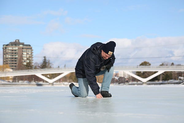 A devastated Bruce Devine is kneeling on the Rideau Canal Skateway, with the Flora Footbridge in the background. We all feel his pain as we accept that the Skateway will not open this season. 