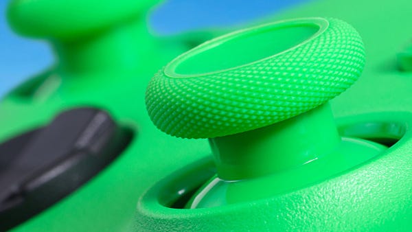An extreme close-up of the Velocity Green Xbox controller shows the two joysticks and D-Pad against the main green of the controller. The two joysticks match the same color green as the face of the controller, while the D-Pad is entirely in black against it. Hints of the blue sky background can be seen poking out from behind the controller.