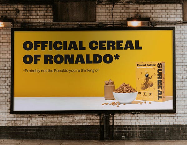 This billboard says "official cereal of ronaldo". In small letters it says "probably not the ronaldo you're thinking of"