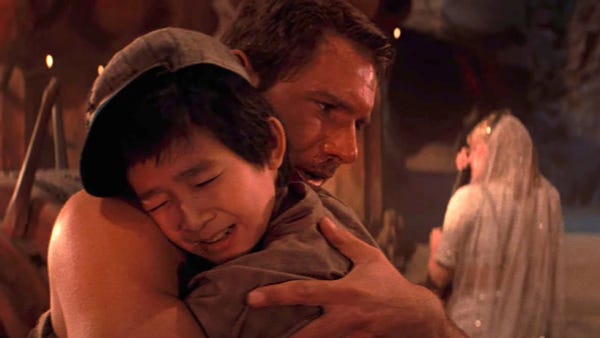 Short round hugging Indiana Jones.