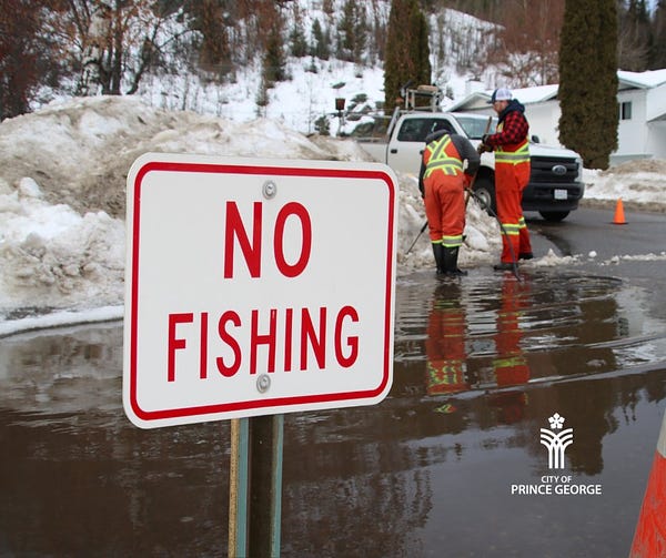 City of Prince George work crew clearing blocked drain on a residential street during the winter. A large sign reads "NO FISHING"
