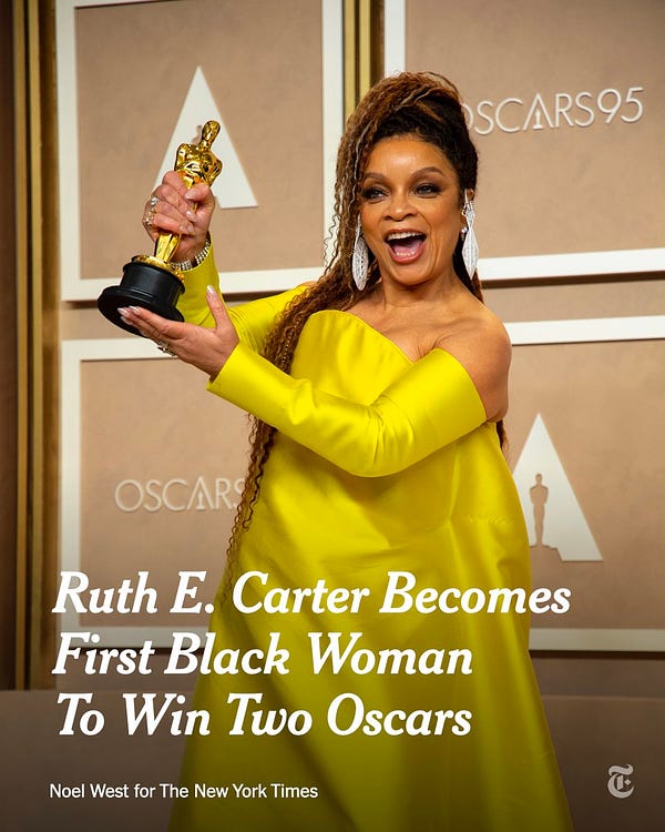A photograph of Ruth E. Carter holding up her Oscar for costume design during the 95th Academy Awards ceremony. A headline reads: "Ruth E. Carter Becomes First Black Woman To Win Two Oscars" Credit: Noel West for The New York Times
