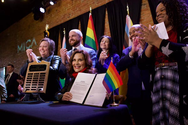 Image of Governor Gretchen Whitmer holding the ELCRA expansion she signed.