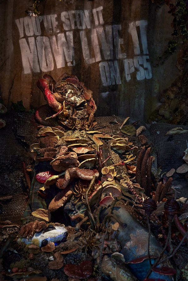 A close-up photo of a Cordyceps infected person on a sofa, their skull and body is covered in fungi and spores. In their right  hand they're gripping a DualSense controller.  They were located in BOXPARK Shoreditch in London. 