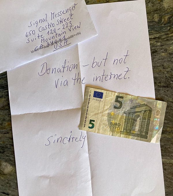 Handwritten letter that reads "Donation - but not via the internet" and a 5 Euro bill addressed to Signal messenger . 