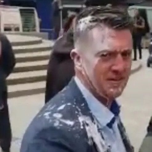 Tommy Robinson crying with milkshake upside his head & 1940s German male/US Army recruit haircut, & splattered down his ill-fitting blue suit