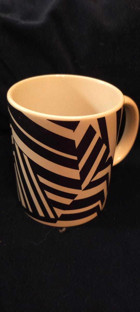 Coffee mug with black and white dazzle pattern on it