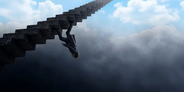 A man walks upside down along the underside of a stone staircase suspended in open air, its top fading into cloud and…