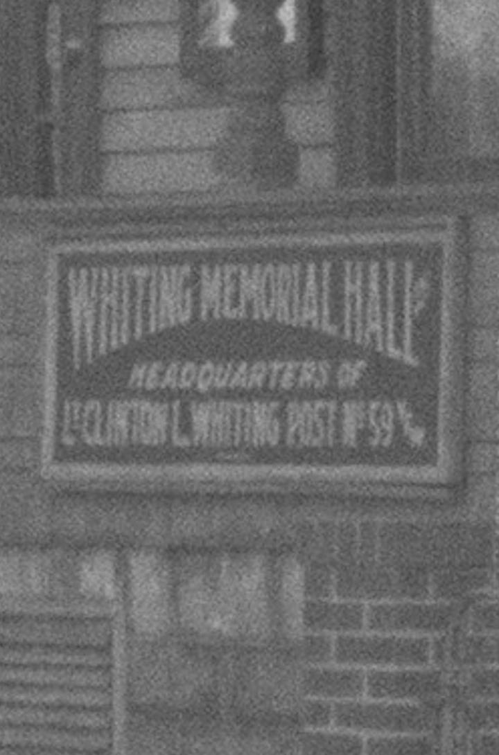 Images show a photograph of Whiting Memorial Hall and a detail showing an enlarged image of the sign on the building.