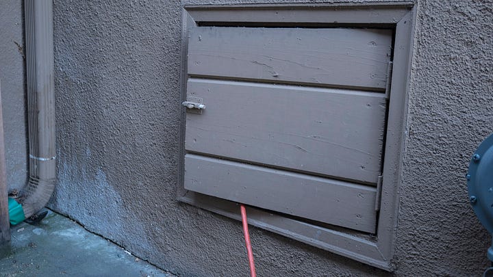 Photo 1: an orange extension cord sneaks out from a wooden access door built into the concrete foundation of a home. Photo 2: closeup of a bottle of "The Montana Distillery" Bacon vodka. In the background, Nancy in a blue top is sipping a glass of vodka.