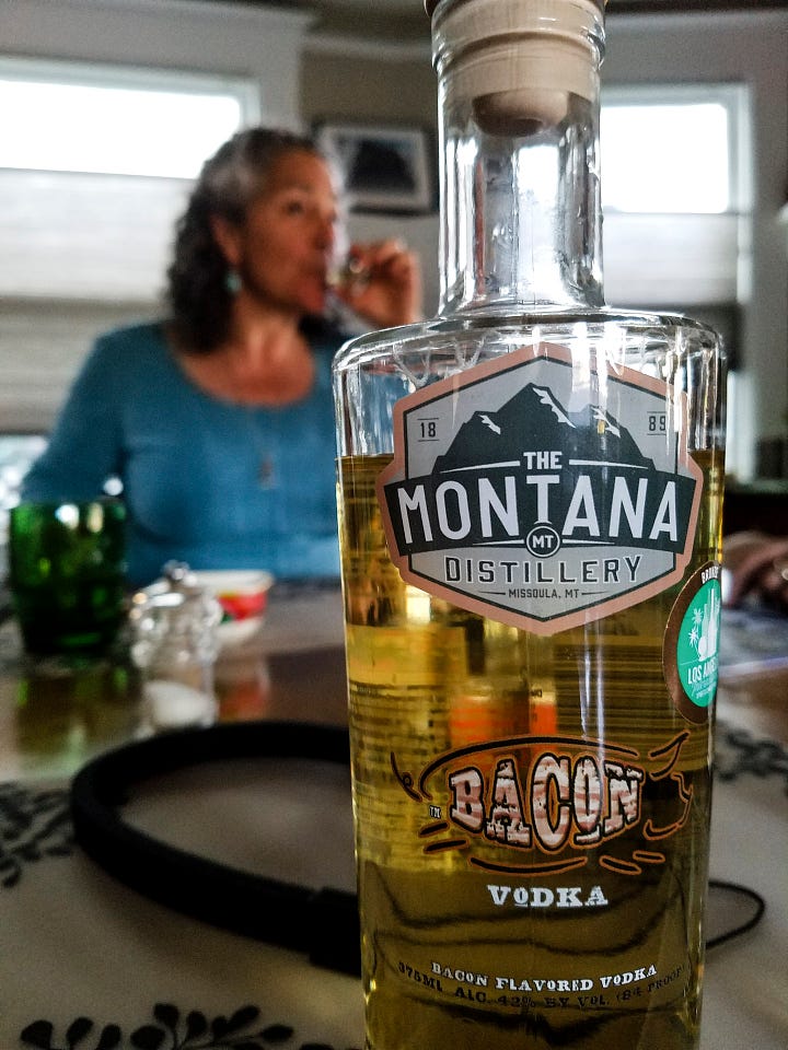 Photo 1: an orange extension cord sneaks out from a wooden access door built into the concrete foundation of a home. Photo 2: closeup of a bottle of "The Montana Distillery" Bacon vodka. In the background, Nancy in a blue top is sipping a glass of vodka.