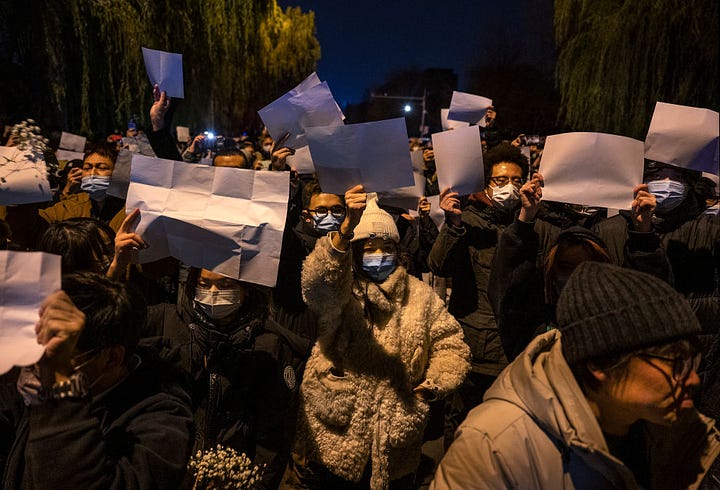 Night time protests in China against Covid restrictions, including people holding up blank paper