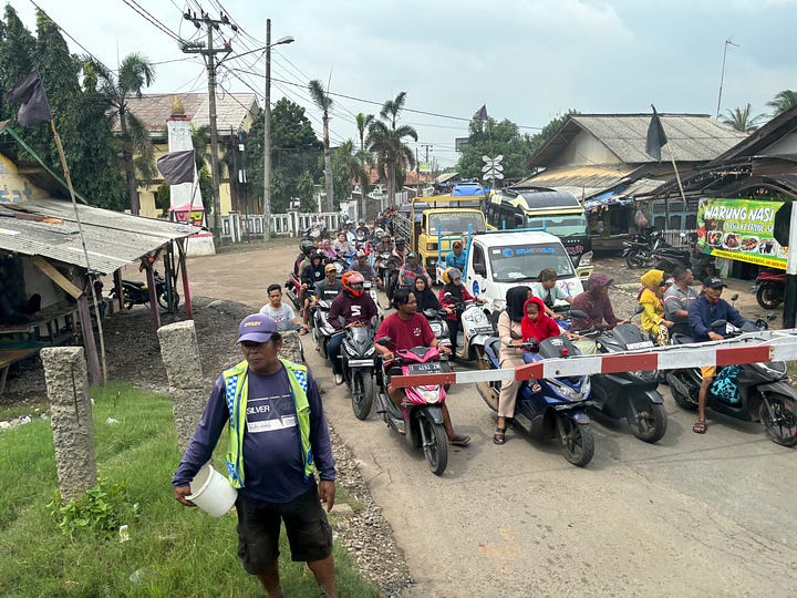 Scooters lining up at Indonesian railroad crossings