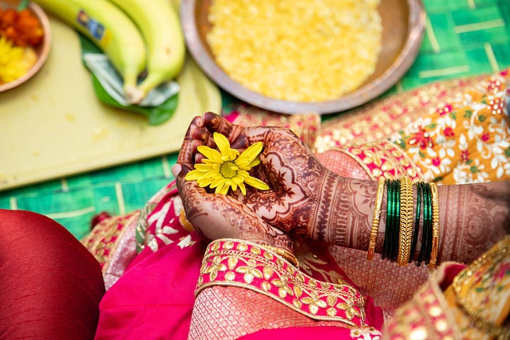 The bride's and groom's hands cup yellow flowers.